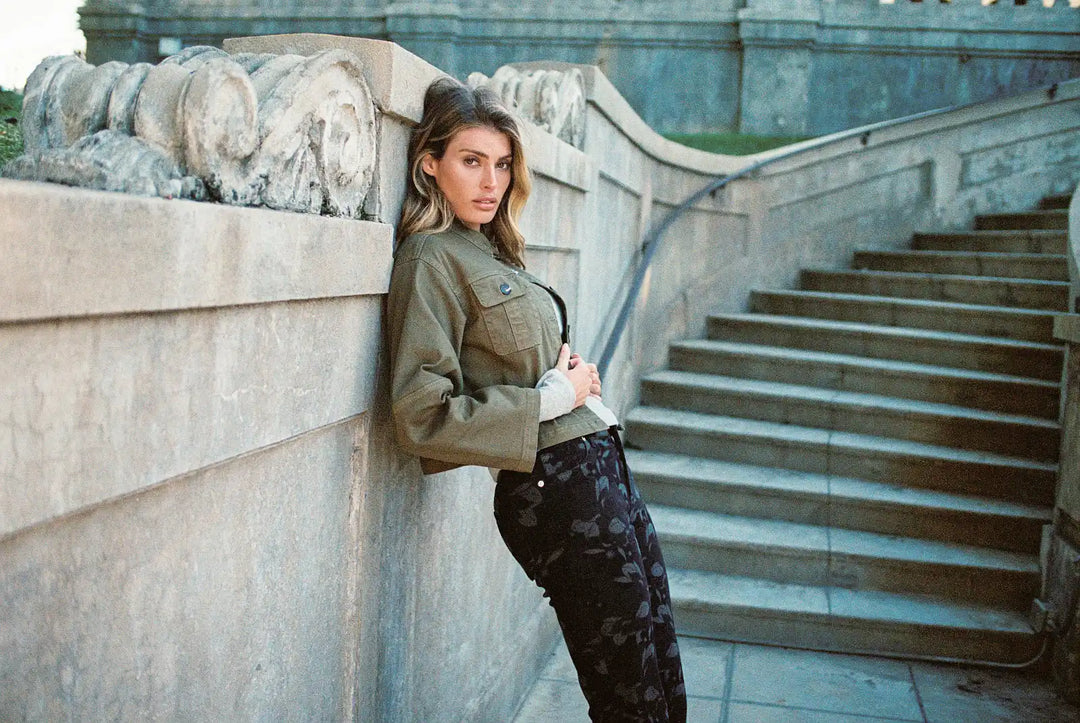 Dear John woman in a cropped jacket against cool stone steps